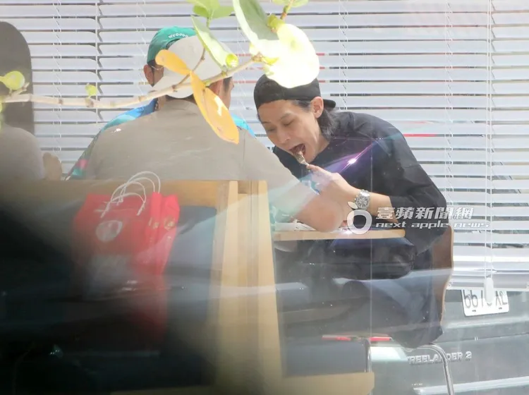 李玉璽（右）插起食物，大口放入口中享用。特勤中心攝