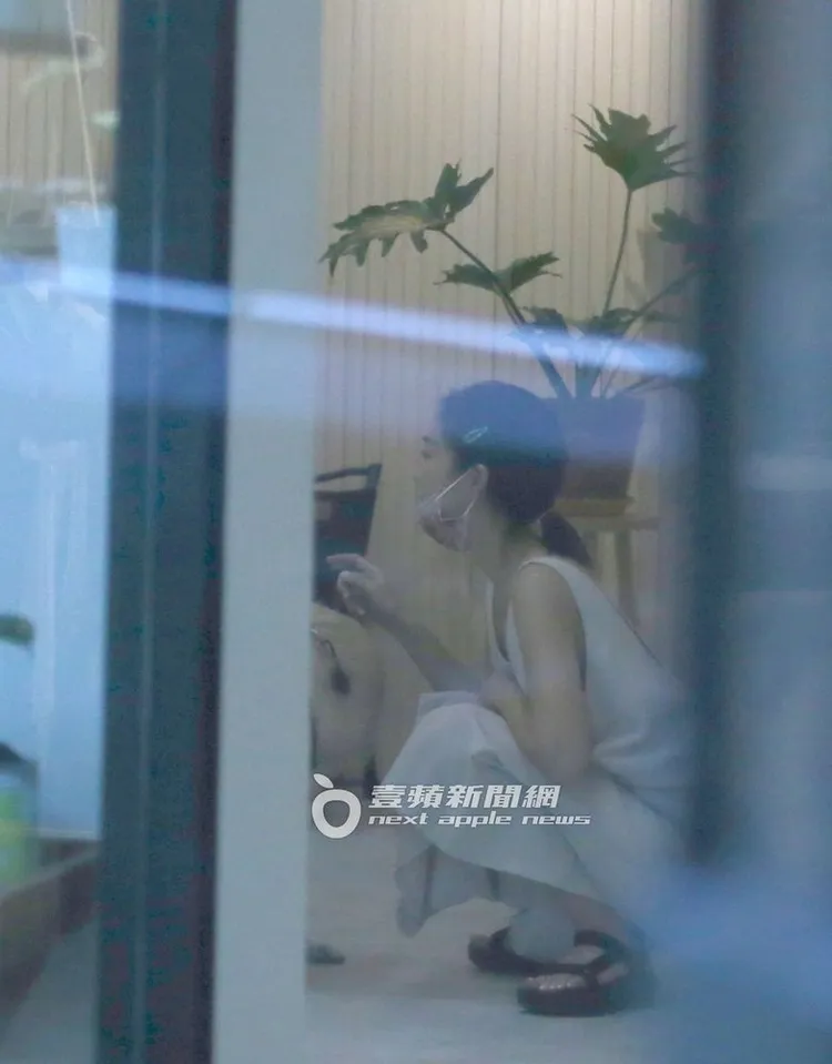 大霈在自家的選物店蹲下與狗狗玩耍。特勤中心攝