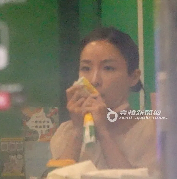 張宇拿起餐點包裝，擋著手上的電子菸，往嘴裡吸了幾口，動作十分熟練。特勤中心攝、《壹蘋》提醒您，抽菸有礙身體健康