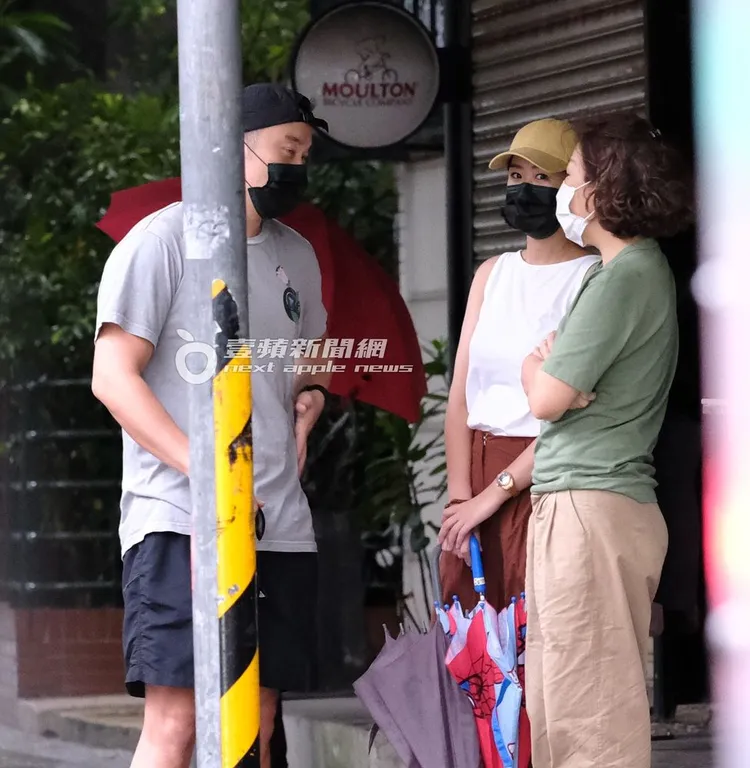 張孝全（左）、老婆（中）與長輩站在騎樓聊天。特勤中心攝