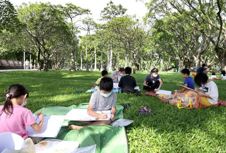 國泰戶外寫生，吸引親子在草地上繪畫，表達對環境的關心。（圖/國泰金控提供）