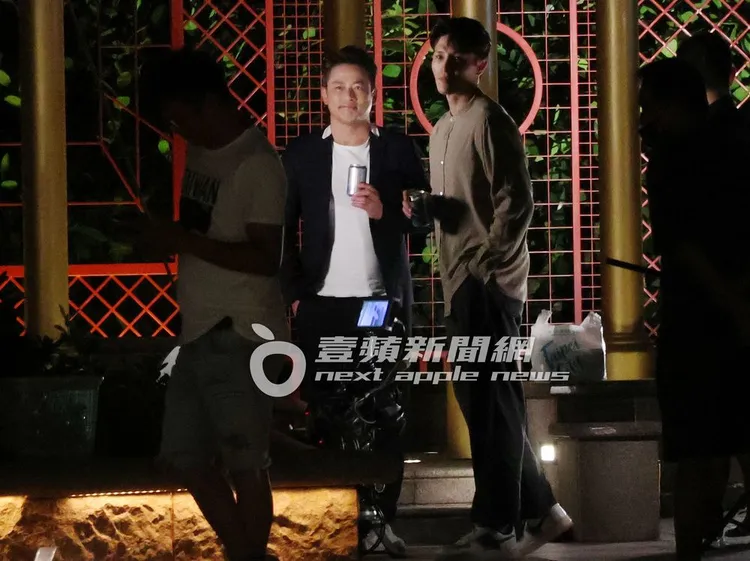  江宏恩（左）與龍語申手拿啤酒罐在公園等戲。特勤中心攝