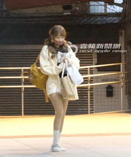 林襄下班後，換上拖鞋拿著行李，邊走邊滑手機。特勤中心攝