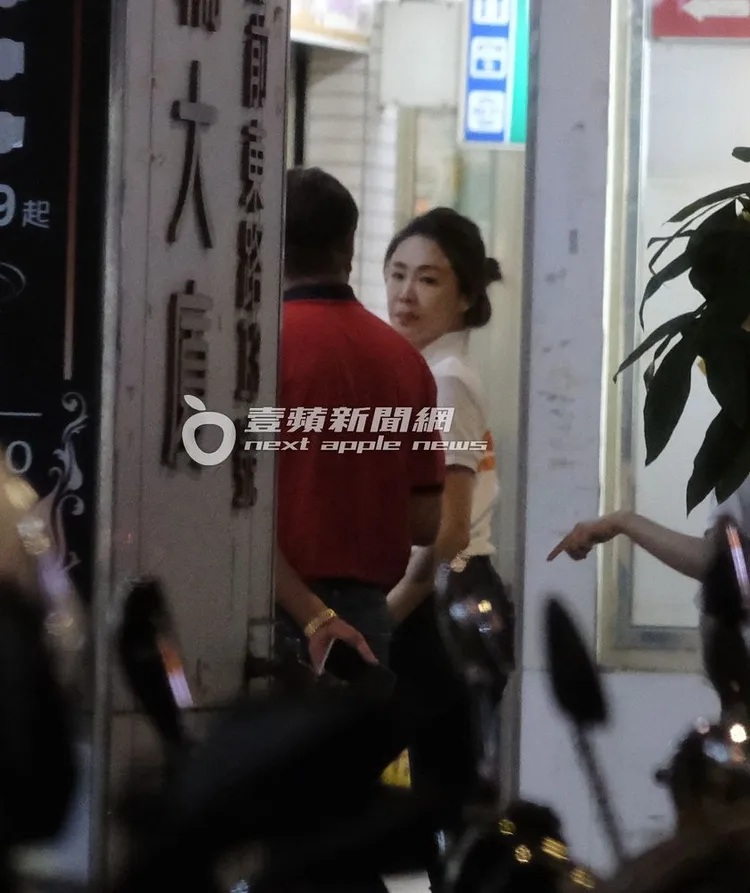 李婉鈺（右）與一名紅衣男走上板橋一間餐廳。特勤中心