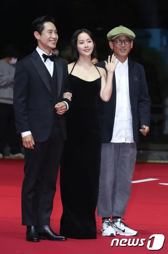 韓志旼（中）剪去一頭長髮，挽著申河均（左）與《Yonder》導演李濬益走紅毯。翻攝news1