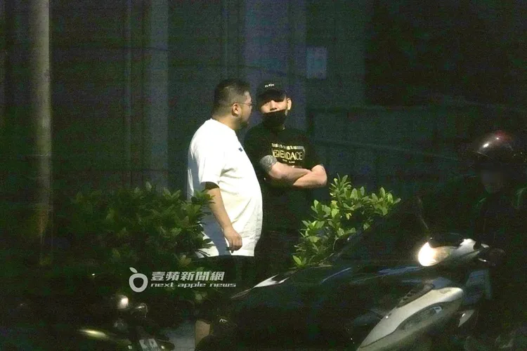 春風（右）雙手交叉的與友人談話準備道別。特勤中心攝