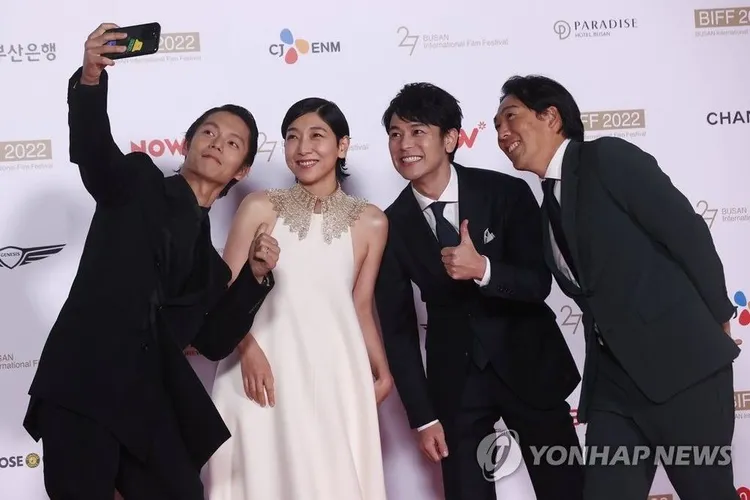 閉幕片《那個男人》導演石川慶（右起）率領妻夫木聰、安藤櫻、窪田正孝參加閉幕典禮，在紅毯上自拍留念。韓聯社