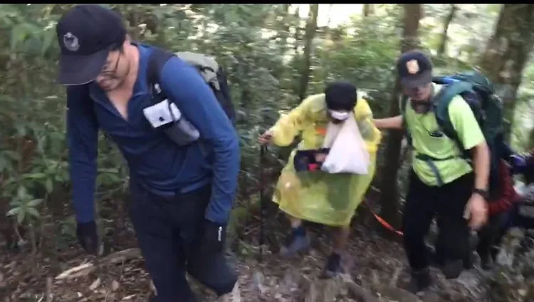 搜救人員沿路扶持傷者到登山口。民眾提供