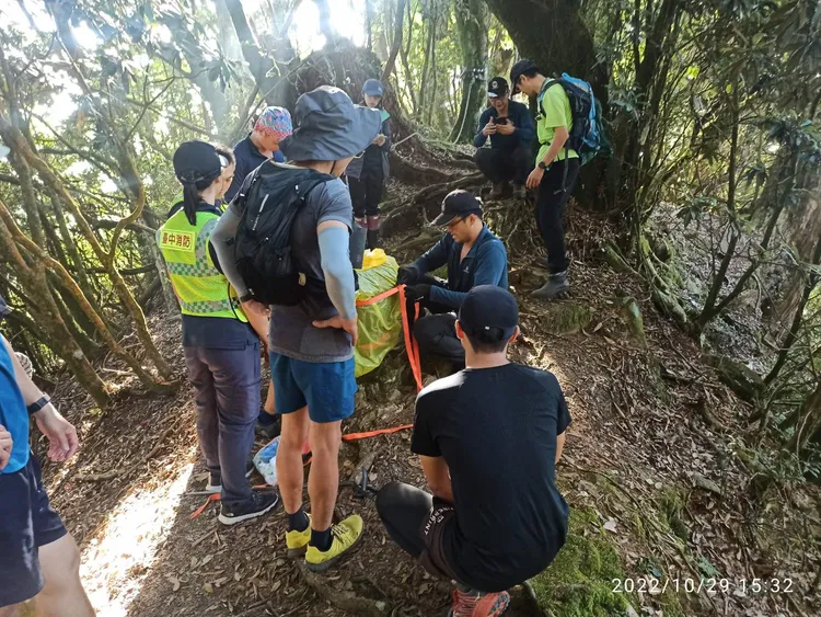 搜救人員接觸傷者後立即檢視傷口，包紮止血後慢慢帶回登山口。民眾提供