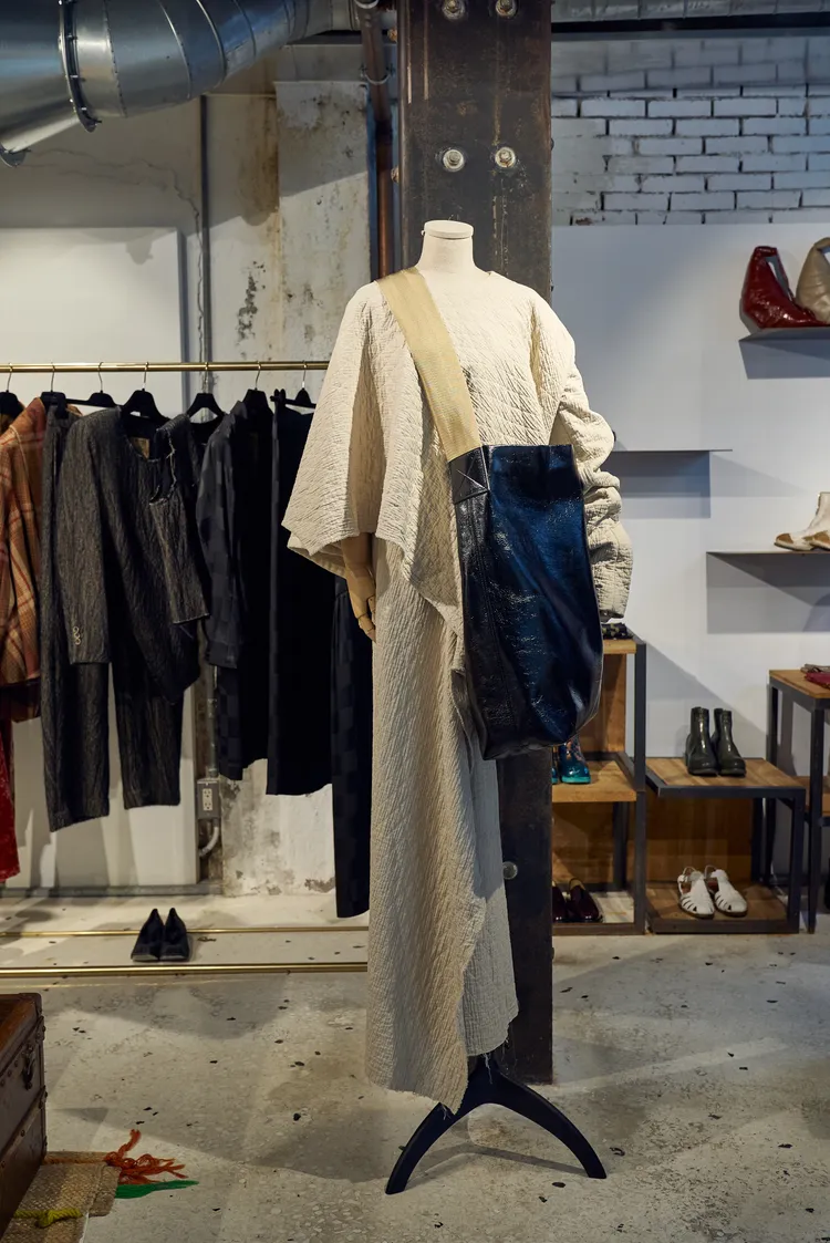 不對稱的圍裹式剪裁以及刻意留下未車縫布邊的細節，呼應了UMA WANG「不完美即是完美」的品牌精神。初衣食午提供