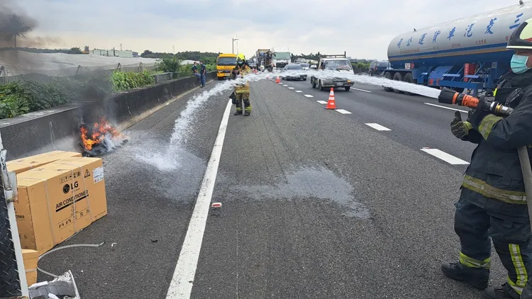 消防人員拉水線撲滅陷入火海的冷氣機。讀者提供