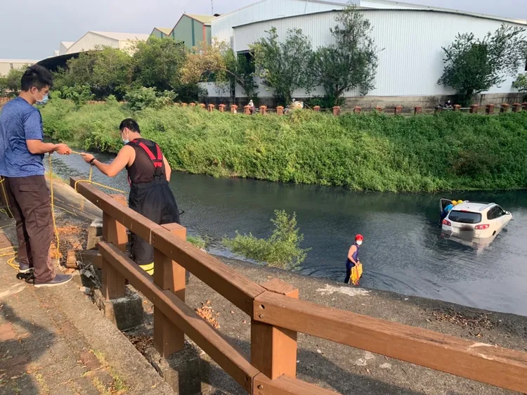 車子衝破人行道圍欄飛落大排水溝內。讀者提供