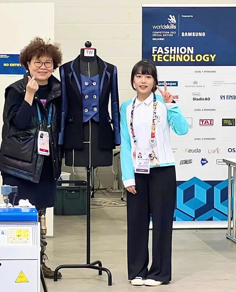 三民家商慕芷瑄（右）以現場製作這件禮服（如圖）勇奪2022國際技能競賽服裝創作銀牌。教育局提供