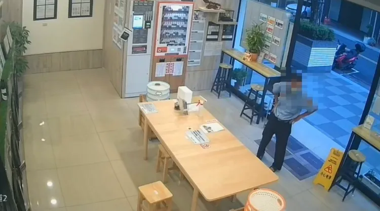 王姓男子走進洗衣店，佯裝顧客、四處打量。讀者提供