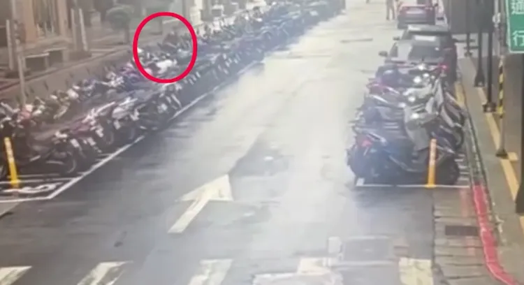 陳男在茫茫車海中尋找沒拔鑰匙的機車。翻攝畫面