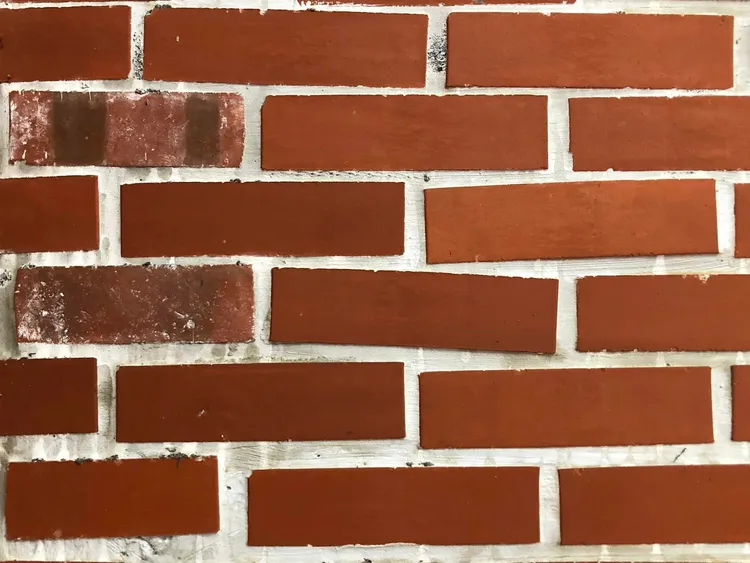 牆面髒污，紅磚未貼齊平整。何子凡提供