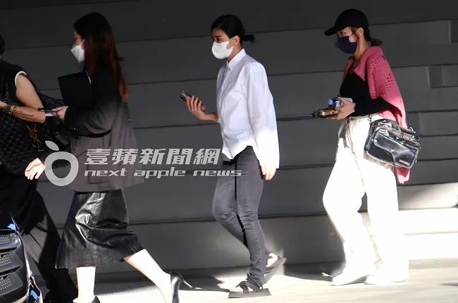 女神賈靜雯（中）出席時尚活動後，換上白色襯衫、搭配黑灰色牛仔褲及時尚拖鞋，準備搭乘保母車離開。特勤中心攝