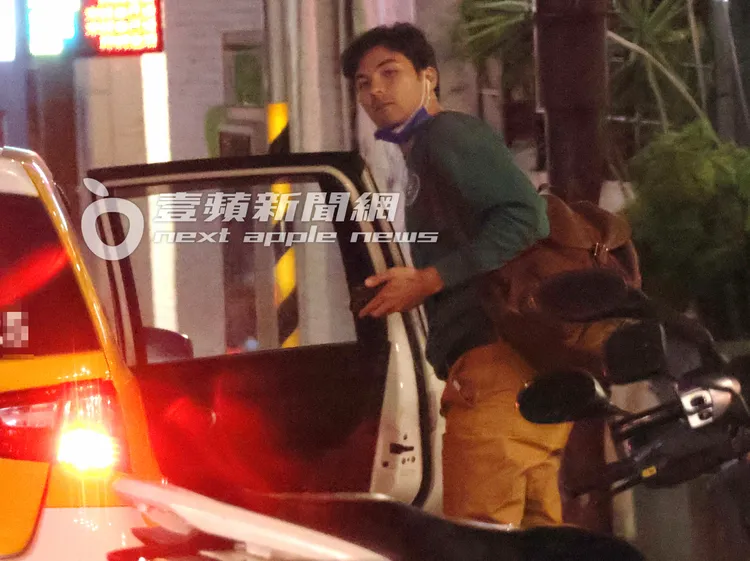 鳳小岳背上背包下計程車，口罩還是沒有戴好。特勤中心攝