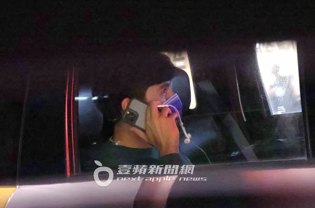鳳小岳在計程車內，邊講手機邊拿著耳機線通話。特勤中心攝