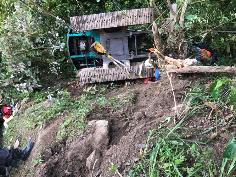 怪手鏟斗抵住不住大樹傾倒壓力，翻滾邊坡、履帶壓住老翁身體。苗栗縣消防局提供