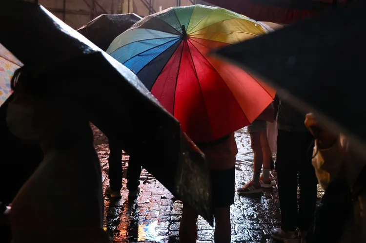 民眾在雨中撐著彩虹傘。林林攝