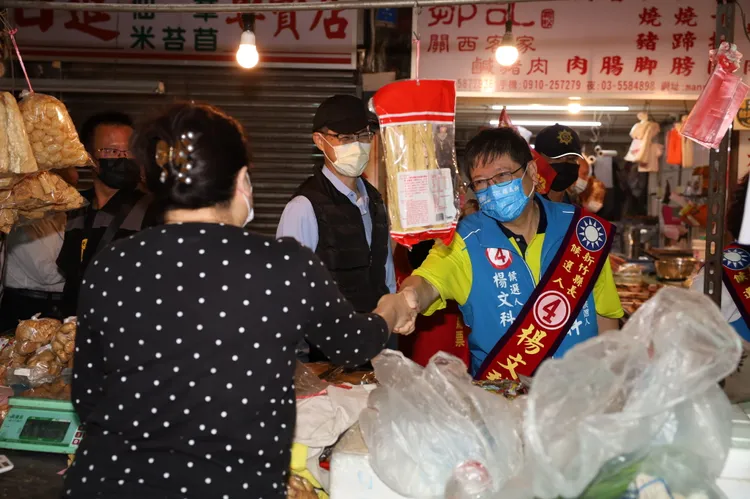 楊文科（右）在關西市場和鄉親熱情打招呼。楊文科競辦提供