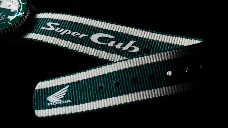 尼龍編織錶帶除了延續綠白相間配色外，且印有「Super Cub」及HONDA標誌的特別字樣。品牌提供