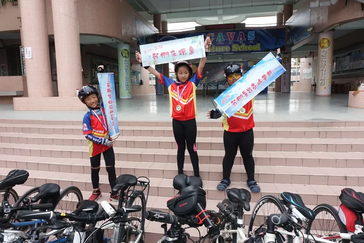 小朋友舉著標語說，「我們是出來吃苦的」。羅琦文攝