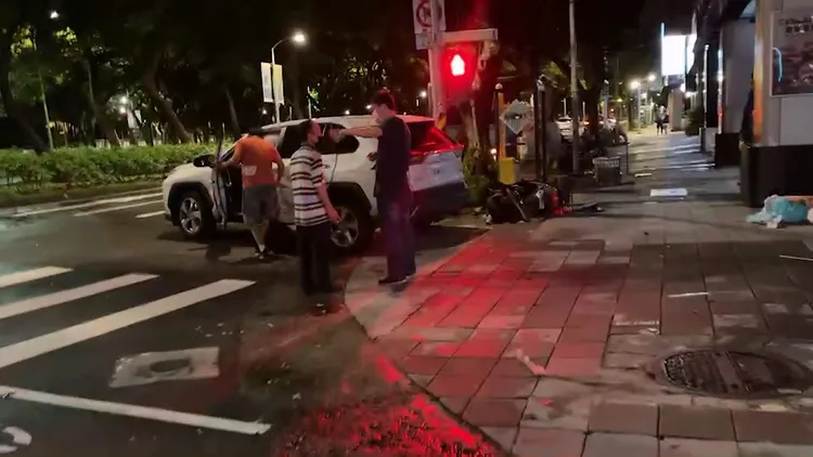 休旅車撞擊後把待轉機車撞飛停在人行道上。翻攝畫面