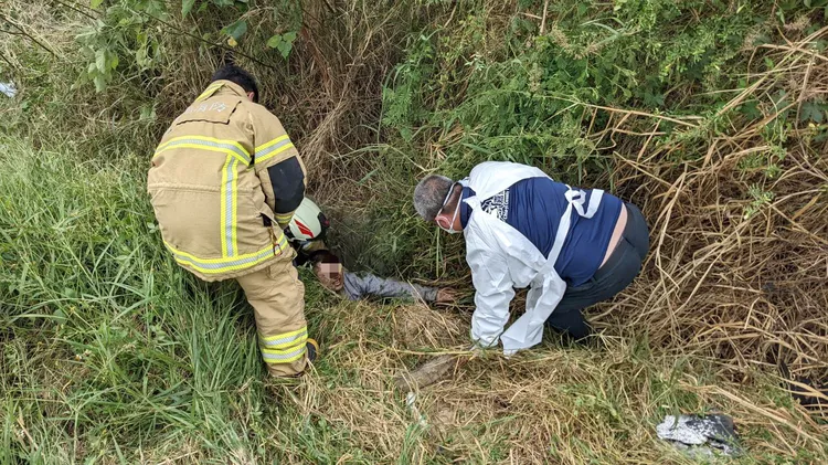 男子遭拋出車外，卡在排水溝中。讀者提供