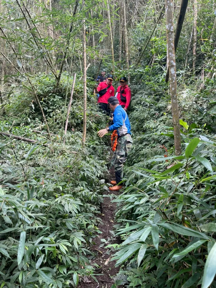 消防局人員輪流將遺體搬運下山。消防局提供