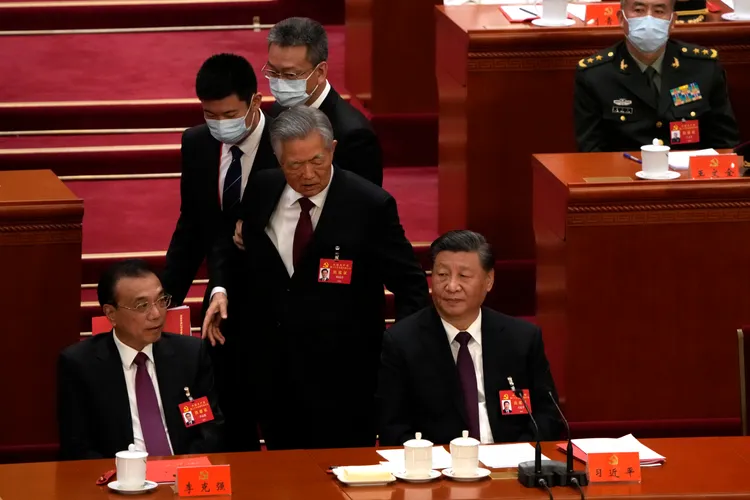 中共前領導人胡錦濤在會議中場起身離場，經過習近平座位。美聯社