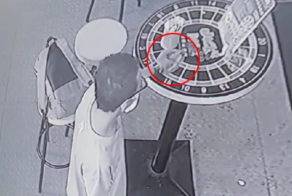 平頭男子伸手到桌上拿起江姓男子的皮夾，用拇指翻開後發現內有一疊千元鈔票，立刻拿皮夾轉身離開。翻攝自高雄大小事