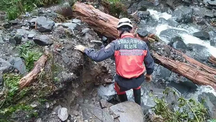 警消在溪流中仔細搜索。宜蘭縣消防局提供