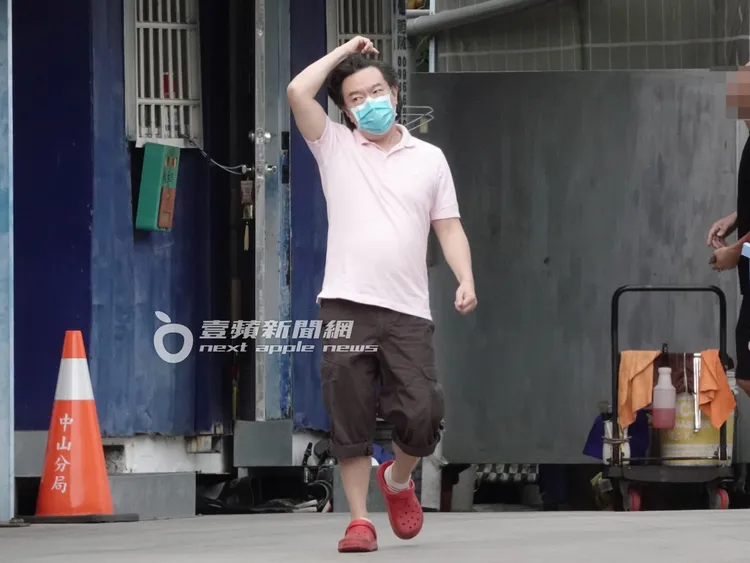 李德立拿著換好的零錢，撥弄著頭髮走回車上。特勤中心攝