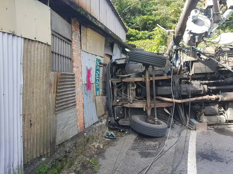 大貨車翻覆後，撞上路旁民宅，所幸屋內並無人員。警方提供