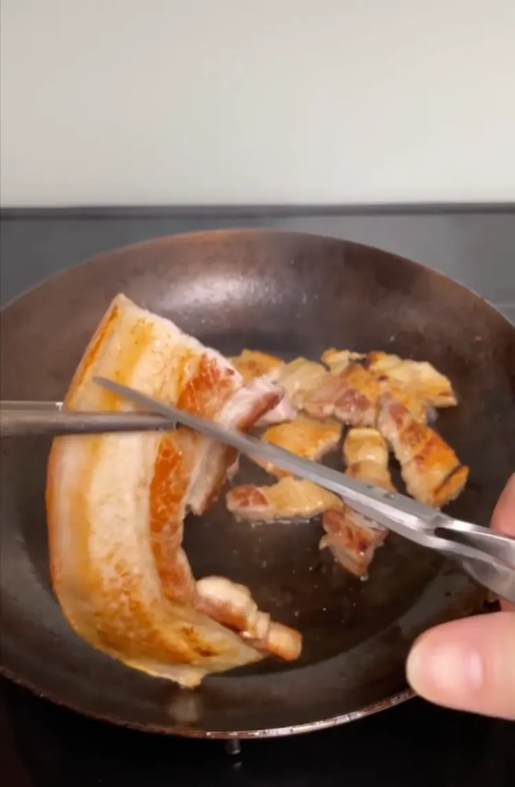 將豬五花煎至金黃色，剪成小塊。