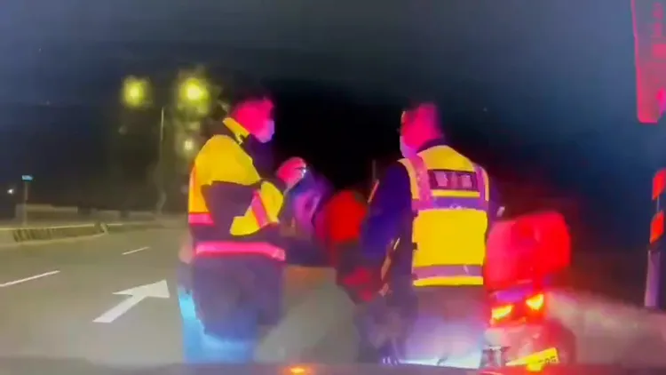 重機騎士向警鞠躬，感激員警平安護送他離開快速道路。警方提供