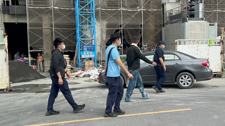 警方將涉嫌打架的工人帶回警局。侯昌騰攝