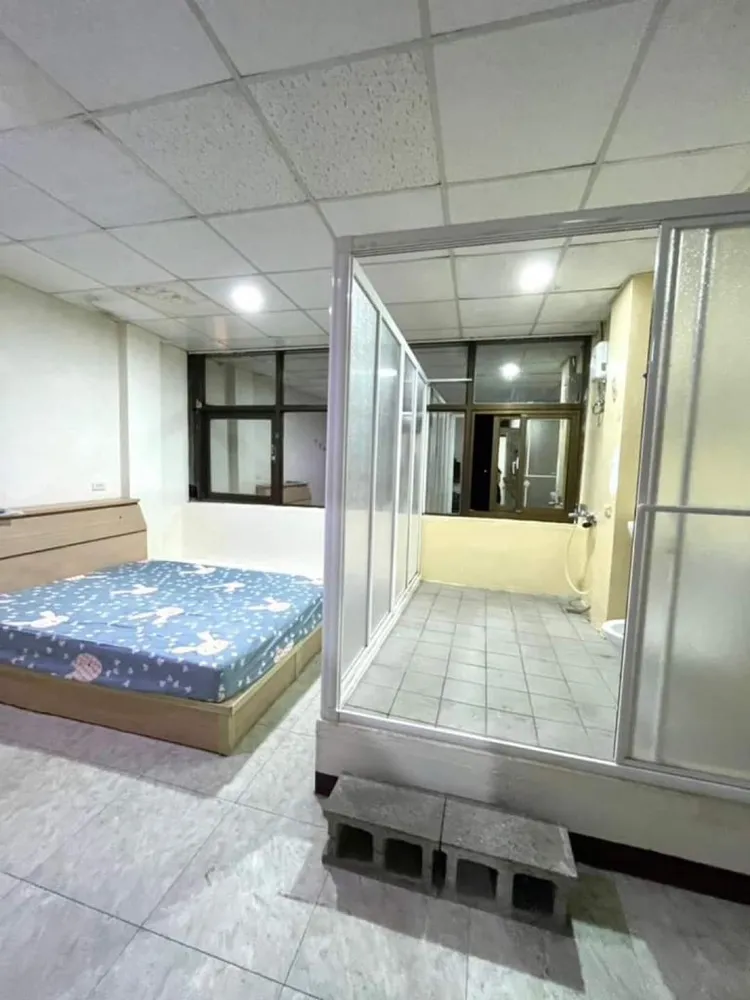 套房擺放一張床，床緣隔壁設置一組衛浴，用輕隔間進行乾濕分離，如廁得踩踏石階進入，地板高度與床面幾乎呈現水平。翻攝租屋平台