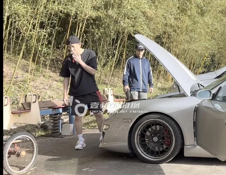 敖犬（左）站在車前，抽著菸整理著行李與曾奕翔聊天。特勤中心攝、《壹蘋》提醒您，吸菸有礙身體健康