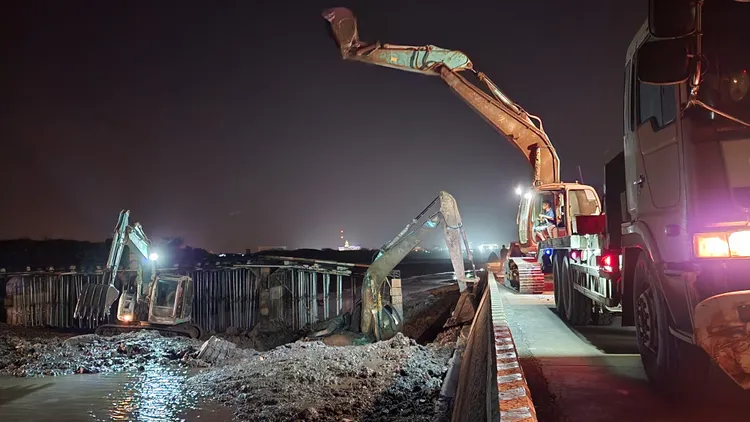 其他怪手幫忙將深陷泥沼的怪手周遭浚挖。許逸民攝