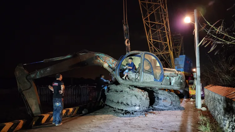 被吊車吊起後脫困的怪手，可見履帶上下全都是爛泥，極為狼狽。許逸民攝