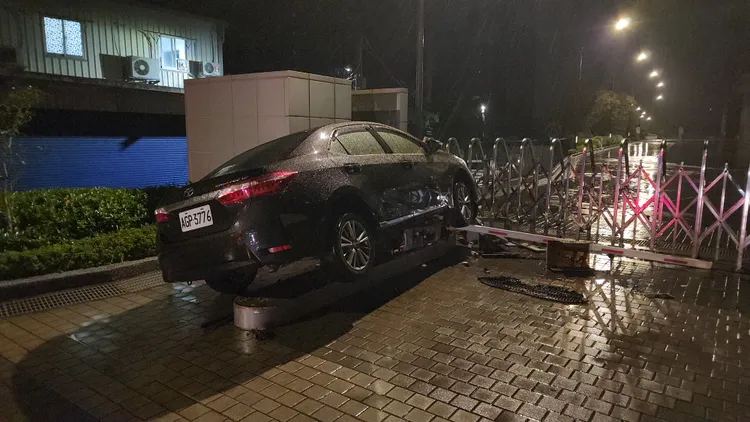 整輛轎車卡在閘門島上。黃仲瑜攝