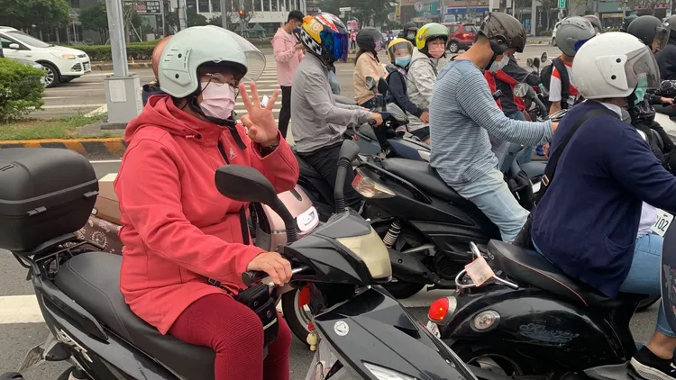 停紅燈的通勤機車族熱情地比出「3｣的手勢幫盧秀燕加油，讓盧秀燕很感動。曾雪蒨攝