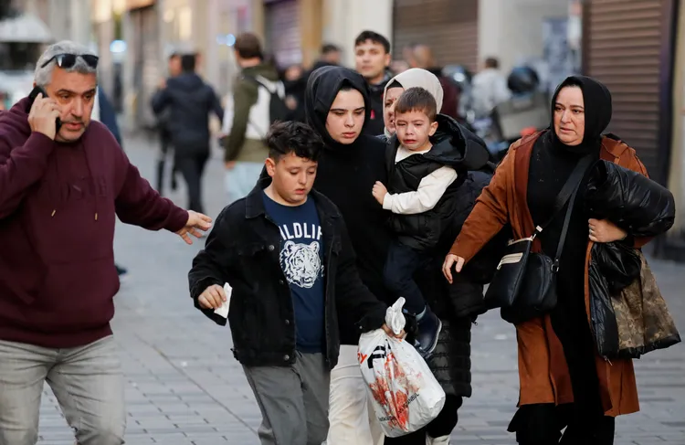 爆炸案後，購物民眾趕緊離開現場，婦女懷中抱著的幼童嚇得哭了起來。路透社