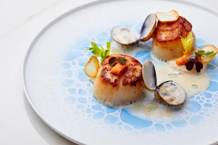 「北海道干貝／根芹菜／海膽」嚴選頂級生食級干貝簡單煎烤，以芹菜根泥調製蛤蠣奶油醬汁，搭配頂級北海道海膽，滿滿的鮮甜海味也呼應港都臨海的城市特質。御盟提供