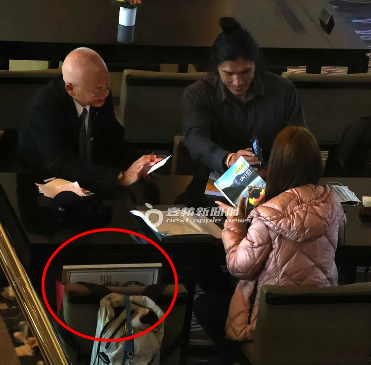 在場的該長輩為鴻琪企業董事長黃楚琪（左）及長髮男都出席曾格爾的演講，她將疑似登山相關的書籍及疑似金氏世界紀錄的證書（紅圈處）放置身旁座位。特勤中心攝