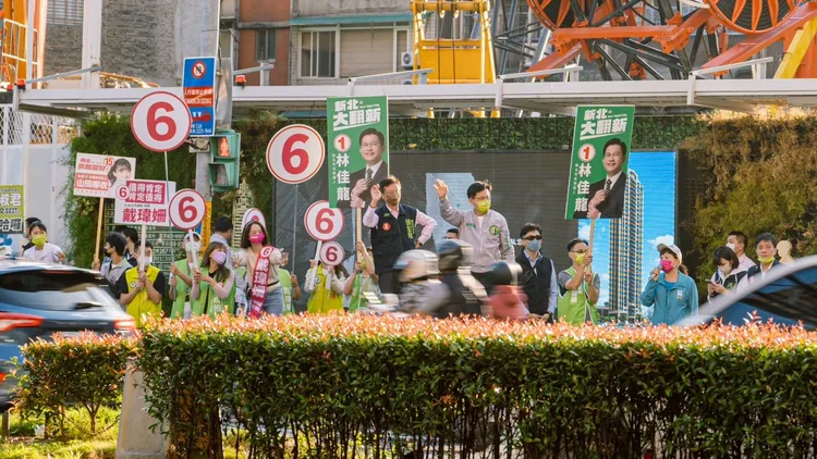林佳龍站在華江橋頭向經過的民眾致意。林佳龍競辦提供