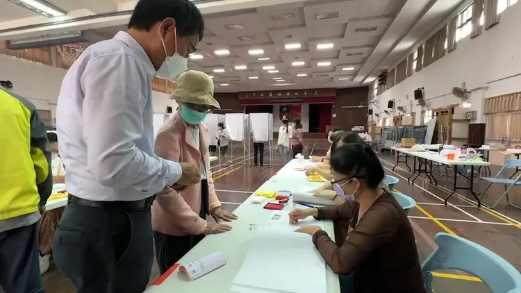 劉建國陪同媽媽完成領票。魏嘉良攝